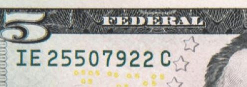 Enlarged excerpt of a $5 note showing the serial number