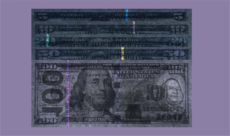 $5, $10, $20, $50, and $100 bills under UV light showing brilliant strips of special thread.